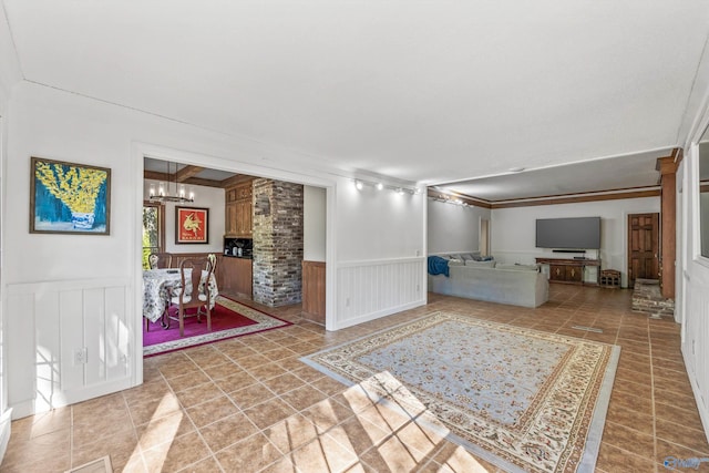 interior space featuring ornamental molding, an inviting chandelier, and tile patterned flooring