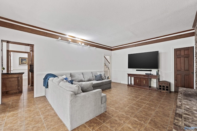 living room with tile patterned floors, crown molding, and a textured ceiling