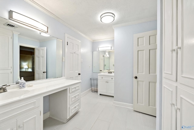 bathroom featuring vanity, ornamental molding, and a textured ceiling