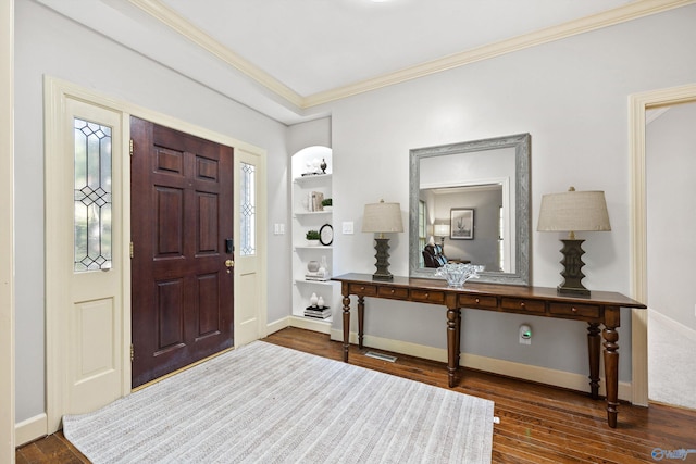 foyer entrance with crown molding and dark hardwood / wood-style floors