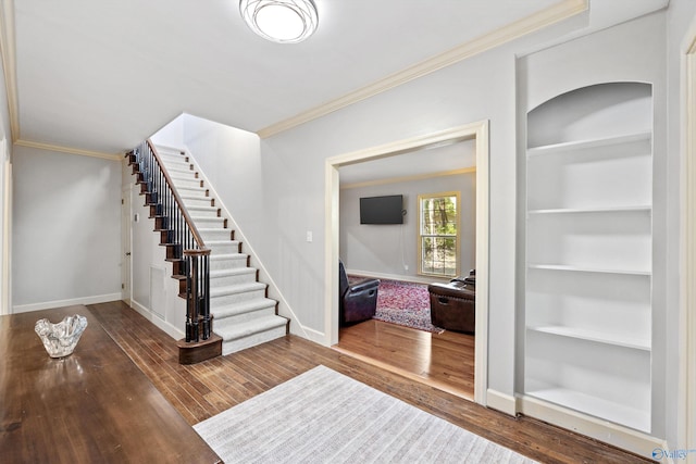 entrance foyer with crown molding and dark hardwood / wood-style floors