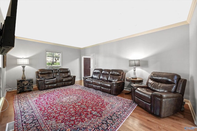 living room with ornamental molding and light hardwood / wood-style flooring