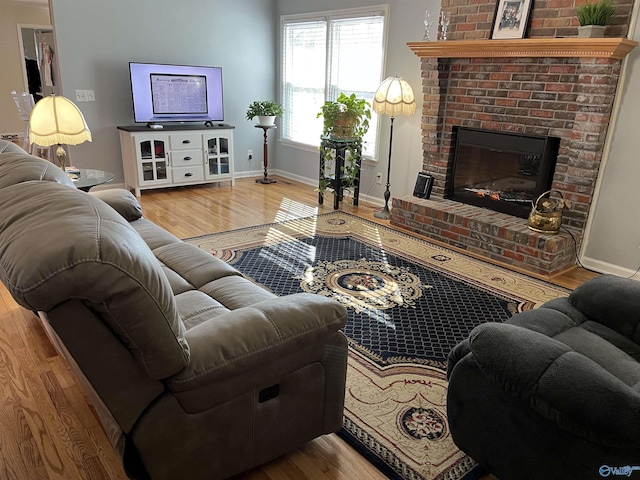 living room featuring hardwood / wood-style flooring and a brick fireplace