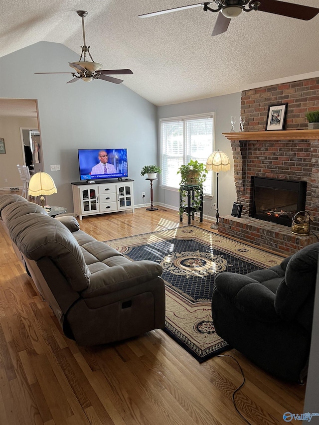 living room with hardwood / wood-style flooring, ceiling fan, and lofted ceiling