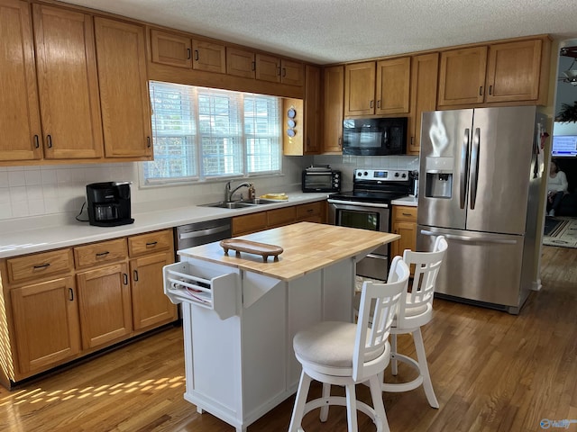 kitchen featuring a breakfast bar area, tasteful backsplash, stainless steel appliances, and wooden counters