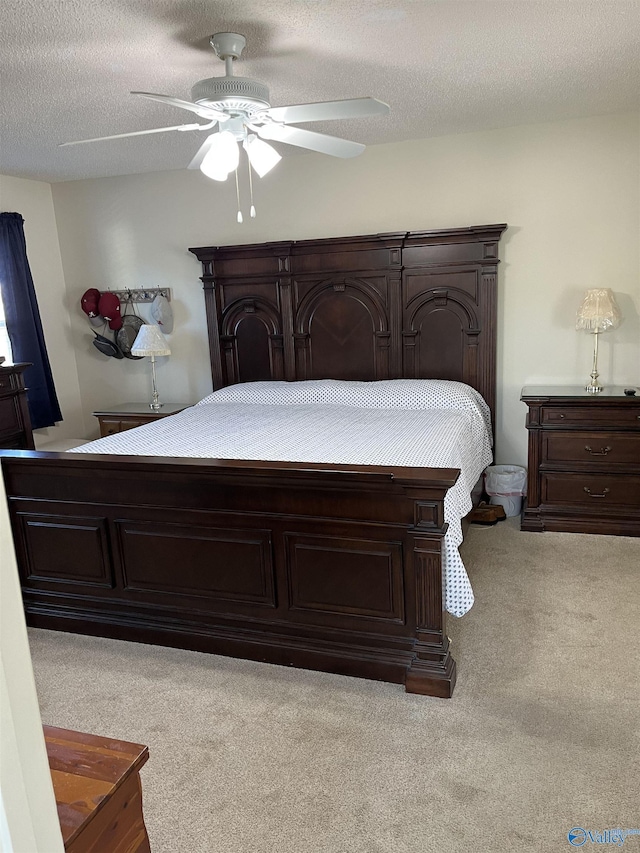 carpeted bedroom featuring ceiling fan and a textured ceiling