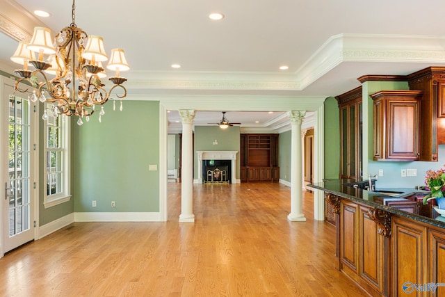 kitchen with ceiling fan with notable chandelier, crown molding, light hardwood / wood-style floors, and decorative columns