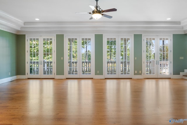 unfurnished living room featuring ceiling fan, crown molding, light wood-type flooring, and french doors