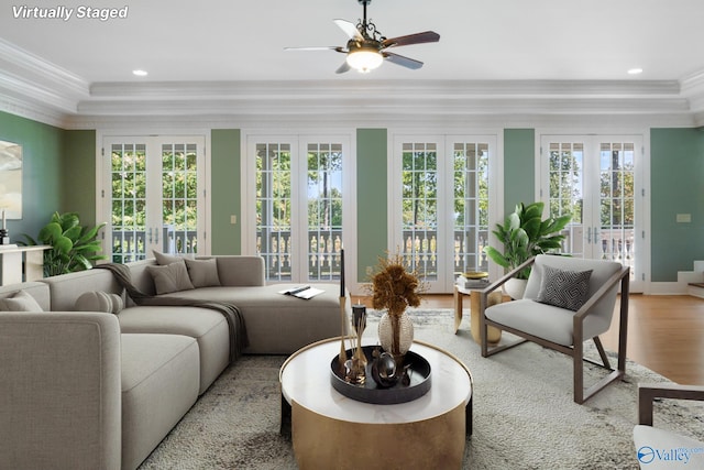 living room featuring plenty of natural light, ceiling fan, ornamental molding, and wood-type flooring