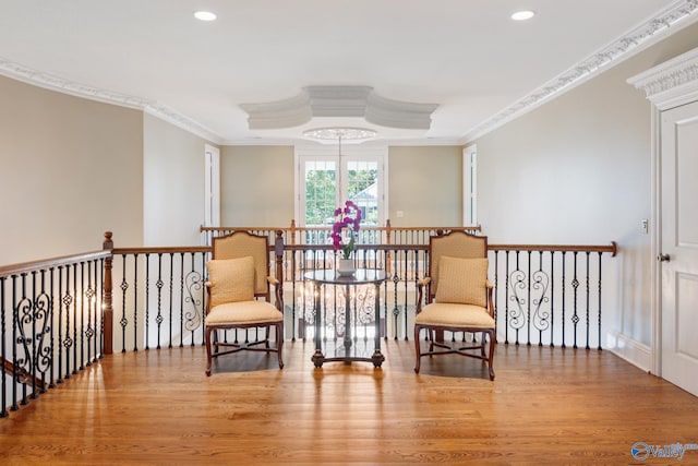 sitting room with light hardwood / wood-style floors and crown molding