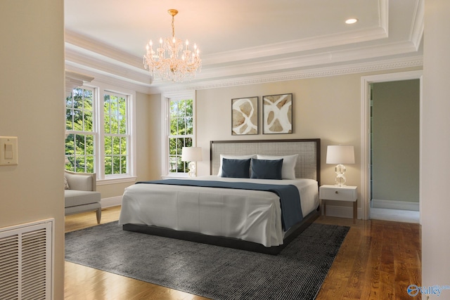 bedroom featuring a raised ceiling, crown molding, wood-type flooring, and an inviting chandelier