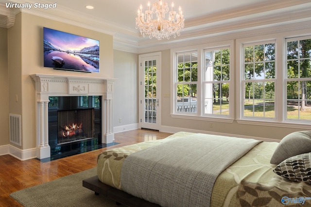 bedroom featuring hardwood / wood-style floors, an inviting chandelier, access to outside, and a tile fireplace