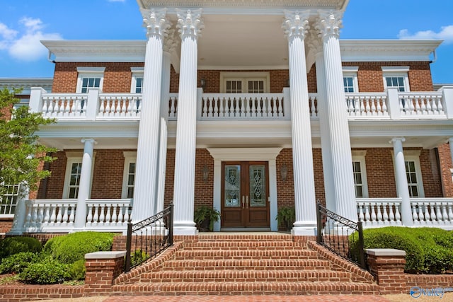 view of front facade featuring a balcony, a porch, and french doors