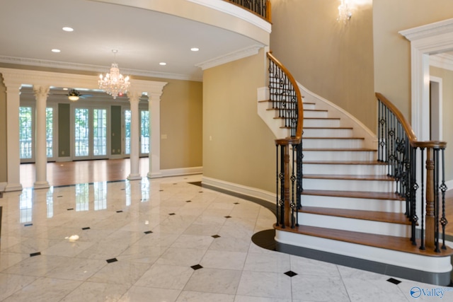 interior space featuring ornate columns, ceiling fan with notable chandelier, light tile patterned floors, and crown molding