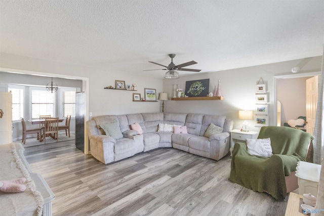 living room with ceiling fan, hardwood / wood-style floors, and a textured ceiling