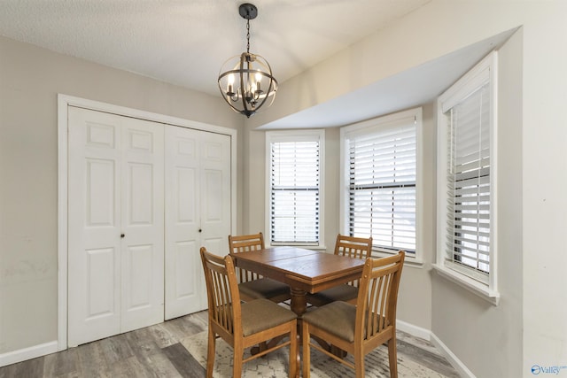 dining room featuring hardwood / wood-style flooring, a textured ceiling, and a chandelier