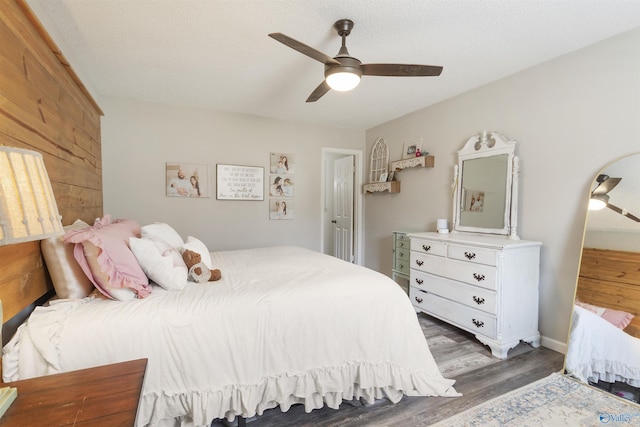 bedroom with ceiling fan, dark hardwood / wood-style floors, and a textured ceiling