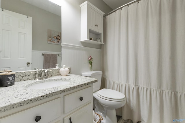 bathroom featuring a shower with curtain, vanity, and toilet