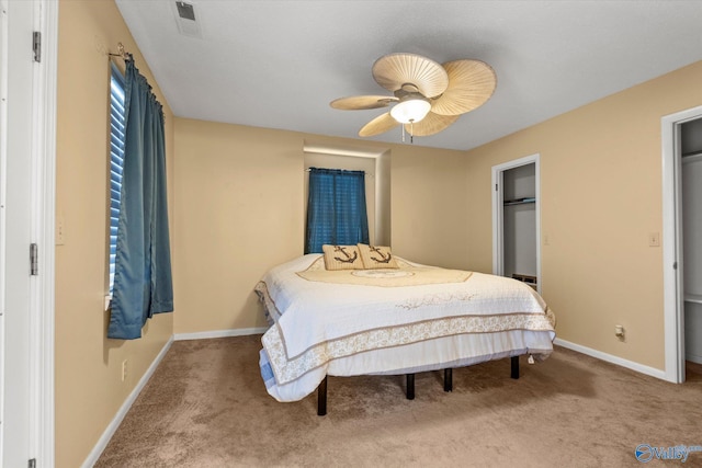 carpeted bedroom with a ceiling fan, visible vents, and baseboards