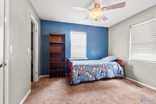 bedroom with carpet floors, visible vents, ceiling fan, and baseboards