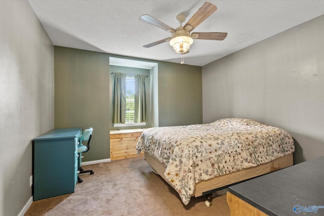 carpeted bedroom featuring ceiling fan, a textured ceiling, and baseboards