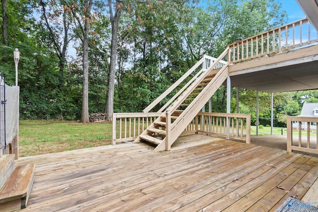 wooden deck featuring stairs and a lawn