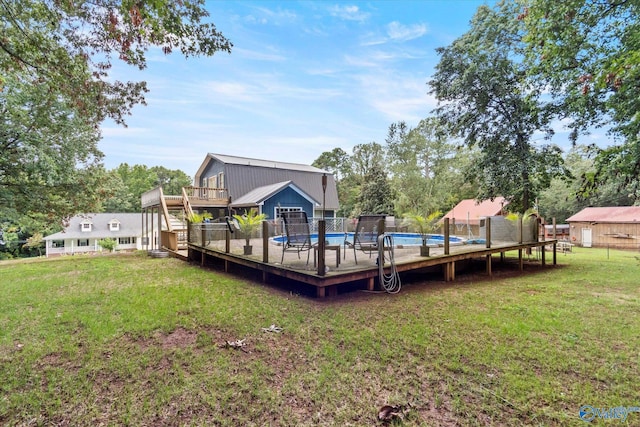 back of house featuring a deck, a yard, stairway, and a fenced in pool