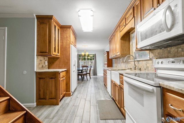 kitchen with light wood-type flooring, white appliances, brown cabinets, and backsplash