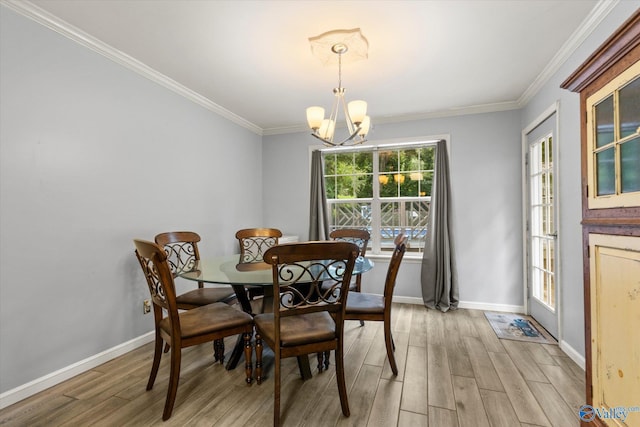 dining room with light wood-type flooring, an inviting chandelier, baseboards, and crown molding