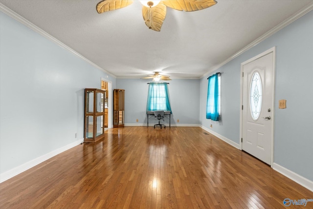 entrance foyer featuring ceiling fan, a textured ceiling, baseboards, ornamental molding, and hardwood / wood-style floors