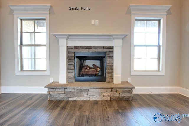 room details with hardwood / wood-style floors and a stone fireplace