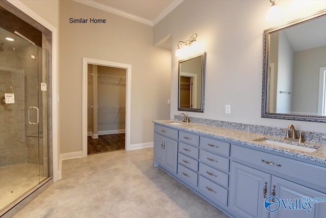 bathroom featuring an enclosed shower, ornamental molding, and vanity