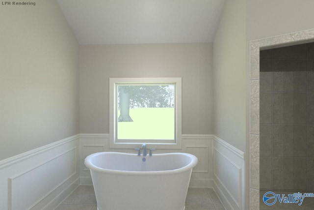 bathroom with lofted ceiling, a tub to relax in, and tile patterned flooring