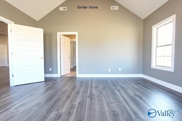 interior space with dark wood-type flooring and high vaulted ceiling