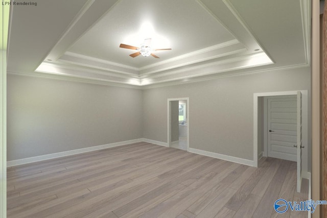 spare room featuring crown molding, ceiling fan, light wood-type flooring, and a tray ceiling