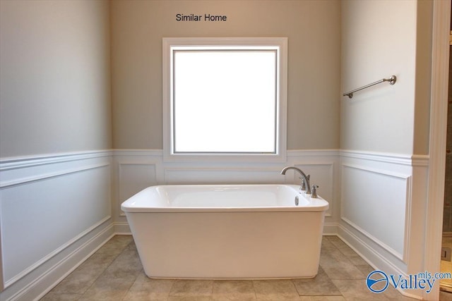 bathroom featuring tile patterned flooring and a tub to relax in