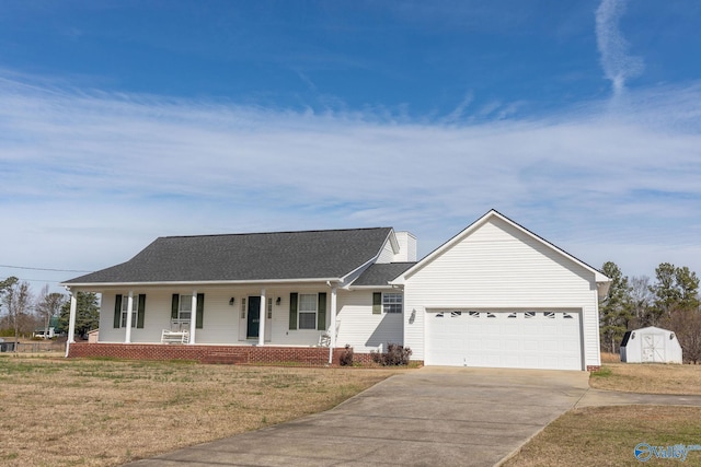 single story home featuring concrete driveway, a porch, an attached garage, a shed, and a front lawn