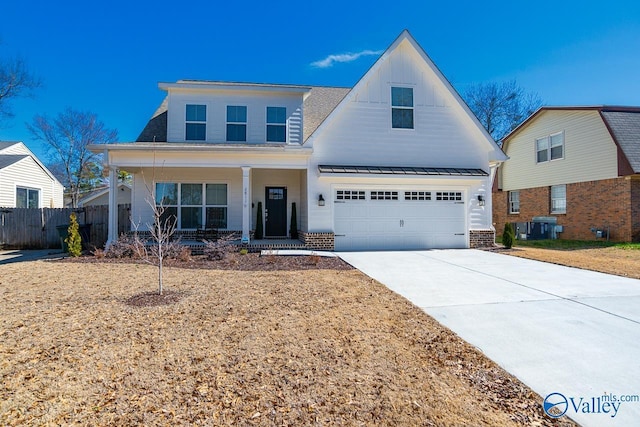 modern farmhouse style home featuring fence, driveway, an attached garage, covered porch, and board and batten siding