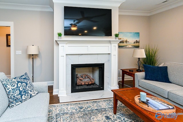 living room featuring visible vents, a fireplace, crown molding, and baseboards