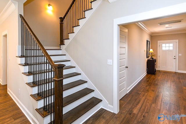 stairs featuring visible vents, crown molding, baseboards, and hardwood / wood-style flooring