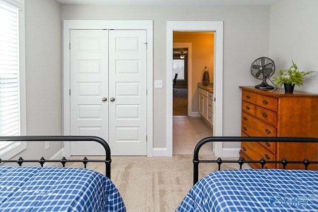 bedroom featuring multiple windows, carpet, a closet, and baseboards