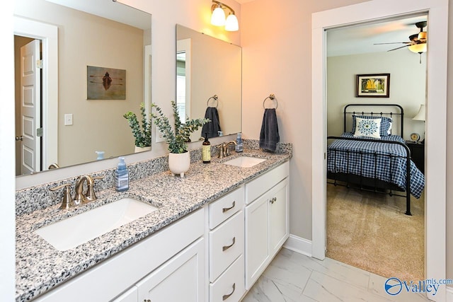 full bathroom with double vanity, marble finish floor, a ceiling fan, and a sink