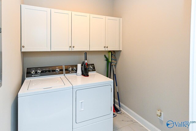 laundry room with separate washer and dryer, cabinet space, marble finish floor, and baseboards