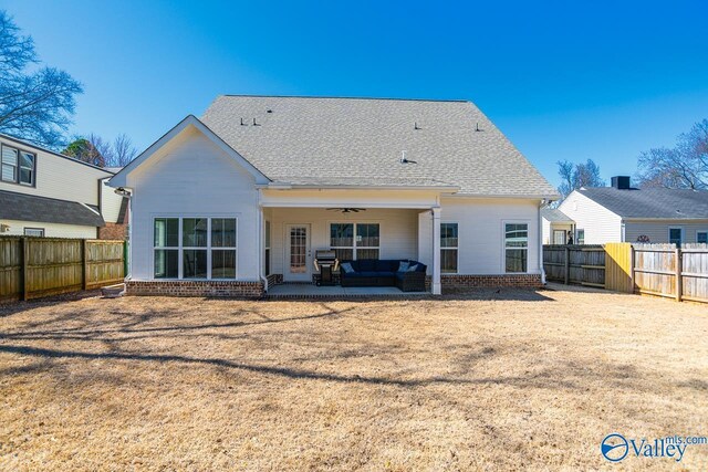 rear view of property with brick siding, roof with shingles, a fenced backyard, a ceiling fan, and a patio