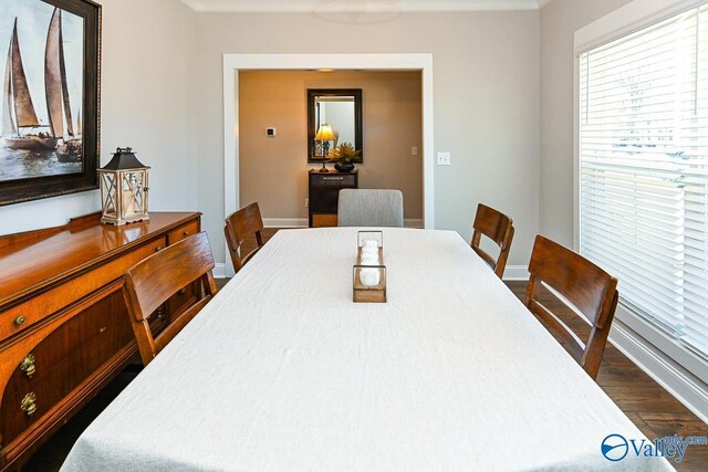 dining room featuring baseboards, dark wood-style flooring, and crown molding