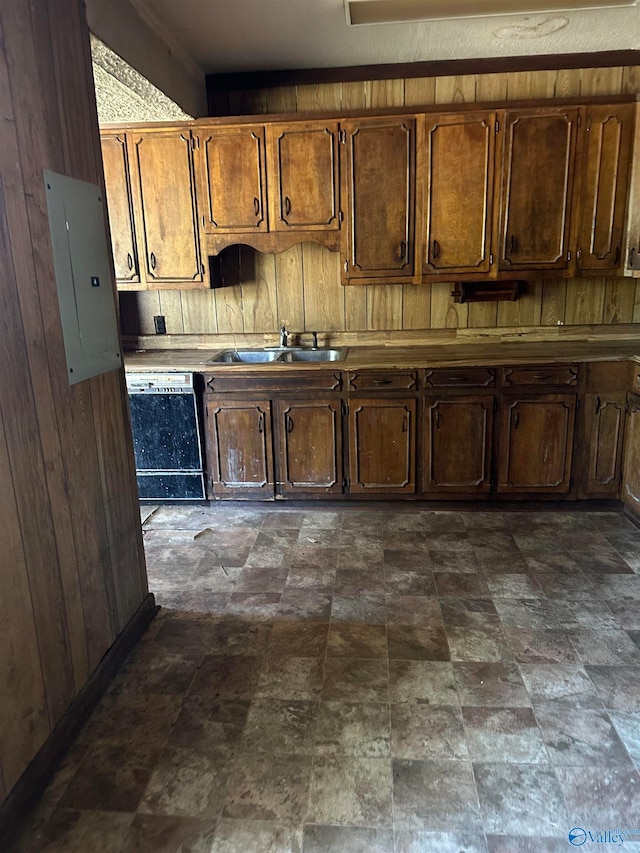 kitchen with dishwasher, electric panel, sink, and wooden walls