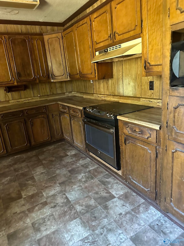 kitchen with a textured ceiling, black / electric stove, and wooden walls