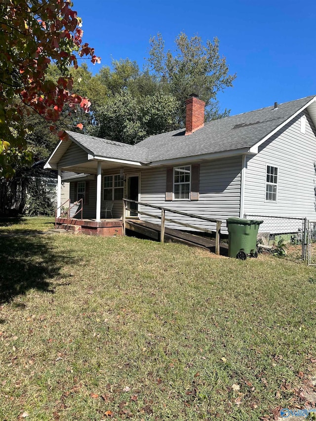 rear view of house with a wooden deck and a lawn