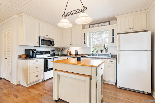 kitchen with a sink, electric stove, freestanding refrigerator, light wood finished floors, and stainless steel microwave