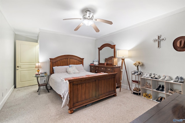 bedroom featuring ornamental molding, light carpet, ceiling fan, and baseboards